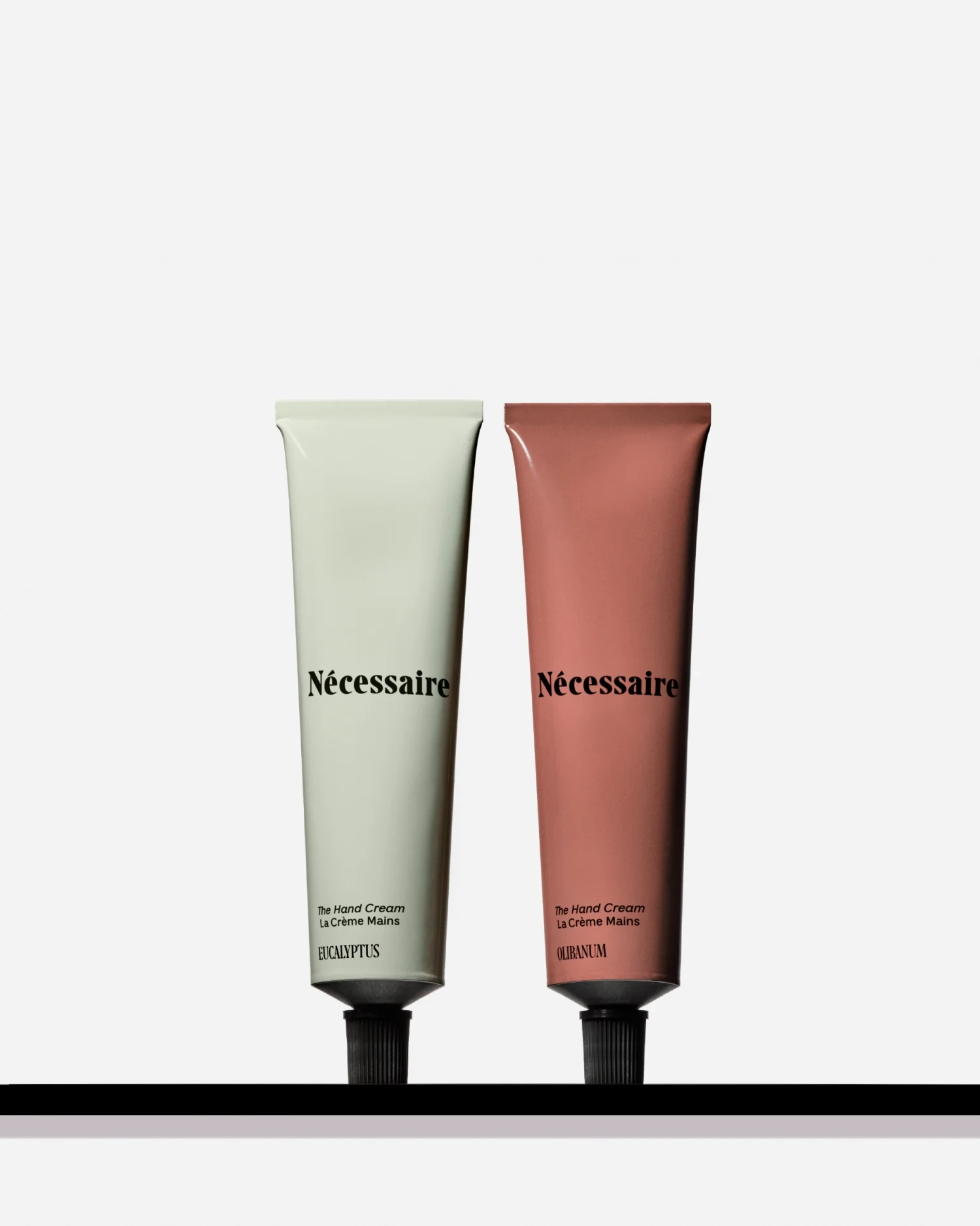 Eucalyptus and Olibanum hand cream tubes standing on a black ledge